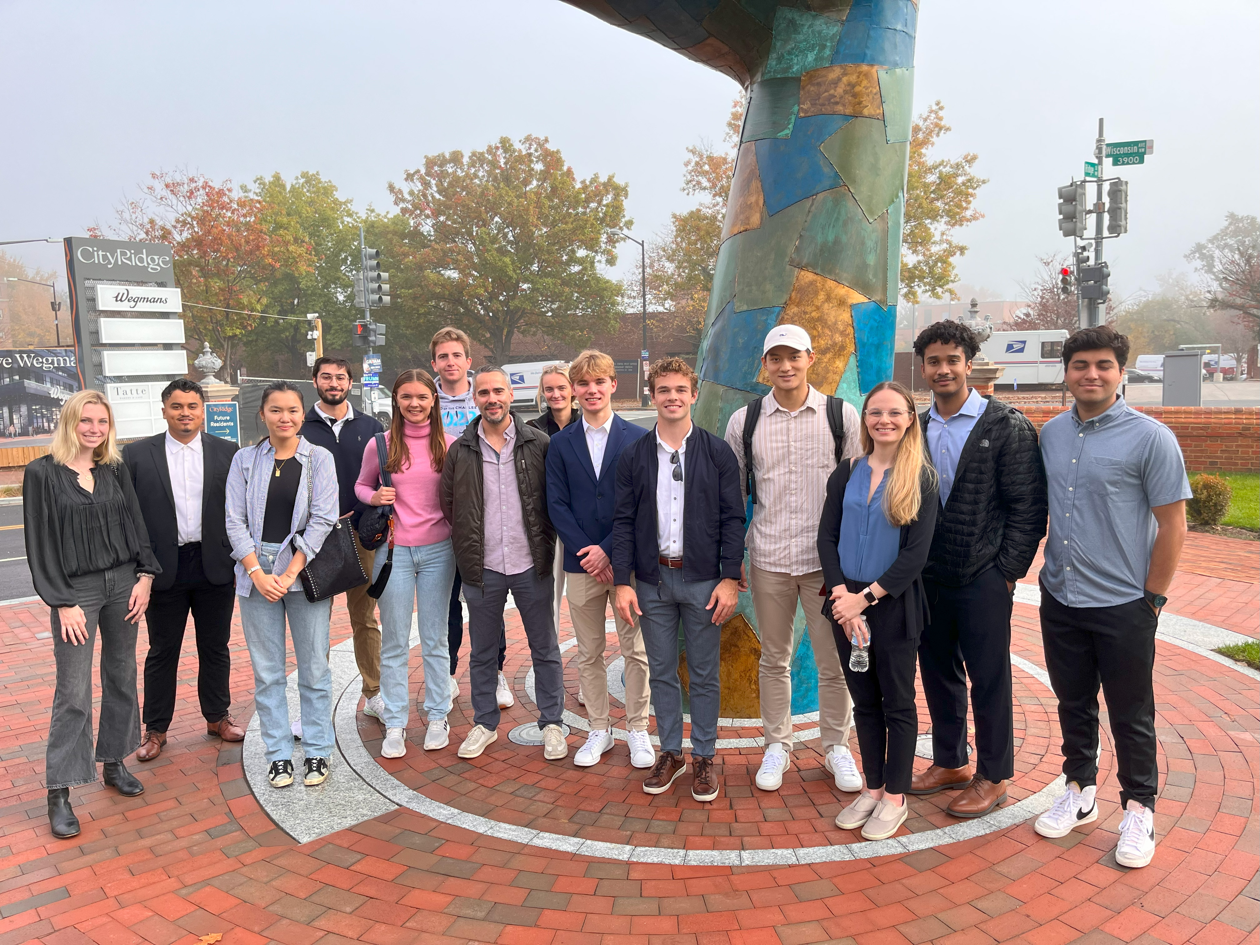 Students take a break during a tour to pose for a photo together in a plaza